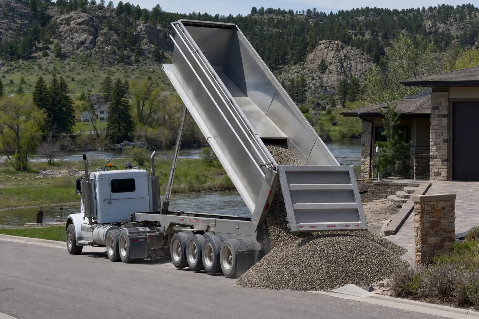 Dump truck delivering gravel to a residential property